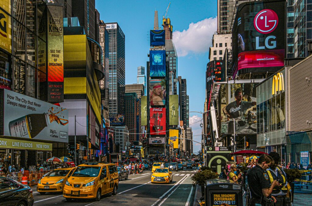 Dynamic street view of Times Square, NYC filled with billboards, taxis, and people.